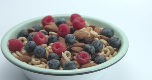 Schwenkbewegung der Kamera von der Schüssel mit Maisringen und Beeren auf weißen Hintergrund — Stockvideo