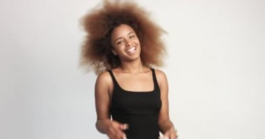 beuayt siyah kadın büyük bir afro saçlı gülen ve başparmak gösterilmesini eğleniyor