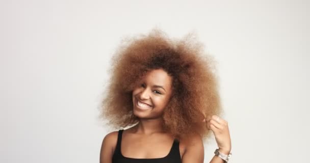 Beuayt μαύρη γυναίκα με ένα τεράστιο Άφρο μαλλιά διασκεδάζοντας χαμογελαστός και να αγγίζει τα μαλλιά της — Αρχείο Βίντεο