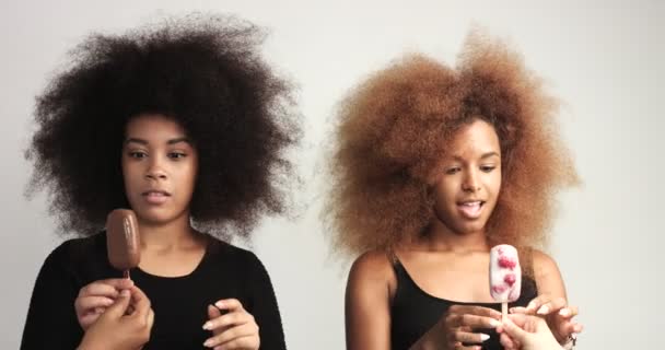 Δύο κορίτσια swith τεράστια αφρο μαλλιά recived παγοκύστη κρέμα κάθε μία και εκπλαγείτε. — Αρχείο Βίντεο