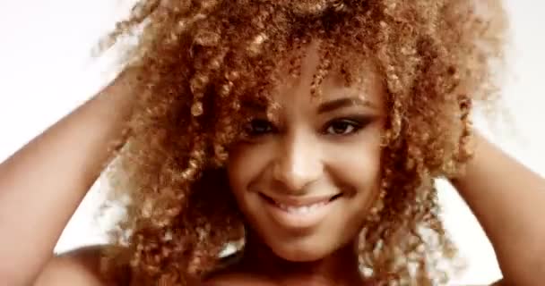 Uroda uśmiechający się mieszane rasy Kobieta, patrząc na kamery i dotyka jej włosy — Wideo stockowe