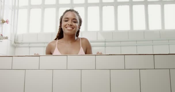 Femme noire sauter oout de l'eau et touche ses cheveux mouillés — Video