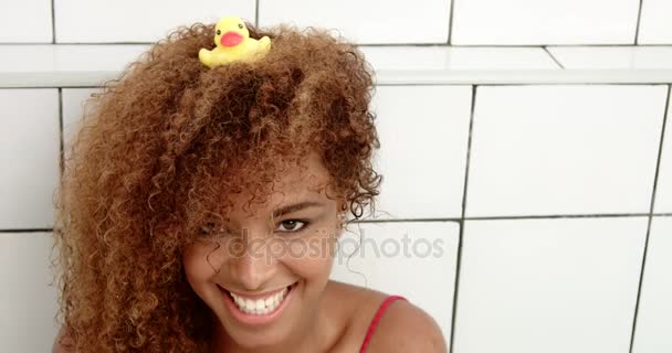 Black womans portrait sitting in bath with a duck on her head — Stock Video