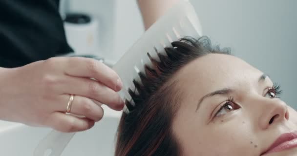 Mujer caucásica en el salón tiene un tratamiento para el cabello con peluquería profesional . — Vídeos de Stock