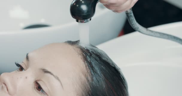 Mujer caucásica en el salón tiene un tratamiento para el cabello con peluquería profesional . — Vídeo de stock