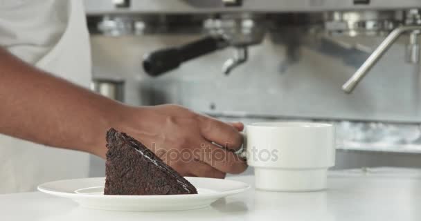 Barista colocar uma xícara de café no primeiro avião para um bolo de chocolate — Vídeo de Stock
