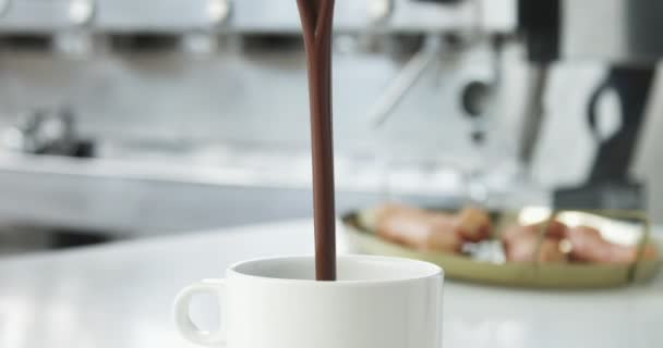 Жидкий горячий шоколад наливается в чашку, а затем палочка испанского пончика, как порры сырой в ней — стоковое видео