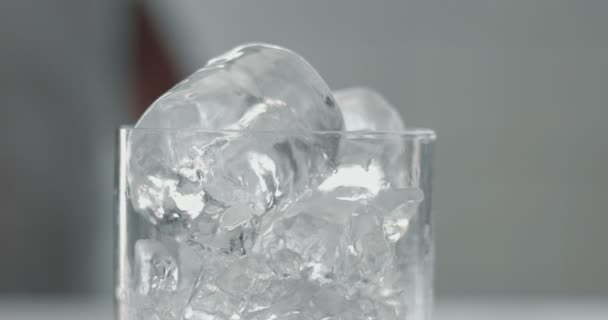 Barist pone un cubo de hielo en vidrio — Vídeo de stock