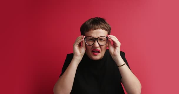 Femme essayer de descern quelque chose, frotter ses yeux et lunettes — Video