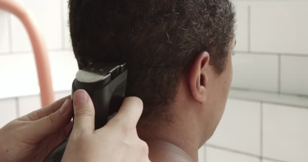 Hombre de raza mixta tiene un corte de pelo en casa en el baño soleado — Vídeo de stock
