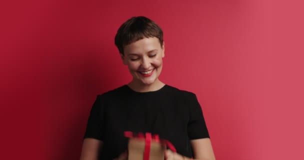 Gelukkig lachende vrouw toss omhoog een doos van de gift — Stockvideo