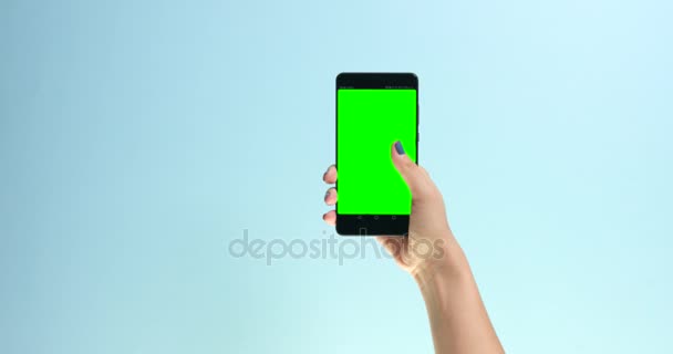 Closeup hand with a smartphone with chromakey display screen making swipe — Stock Video