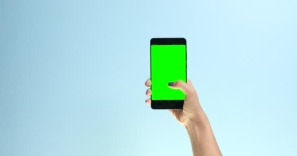 Closeup hand with a smartphone with chromakey display screen making swipe — Stock Video