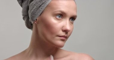 kadın bir krem yüzüne koyar.