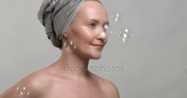 Mulher usa uma toalha com bolhas de sabão — Vídeo de Stock