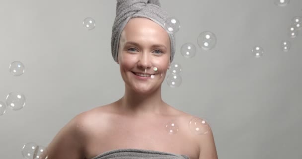 Woman wears a towel with soap bubbles — Stock Video