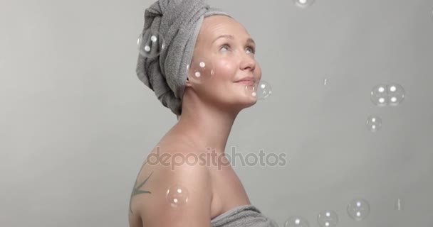 Mujer lleva una toalla con burbujas de jabón — Vídeo de stock