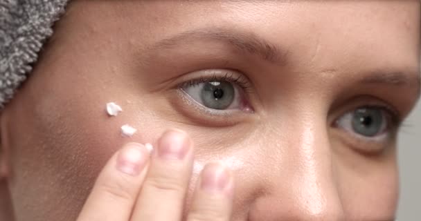 Mujer pone una crema en la cara — Vídeo de stock