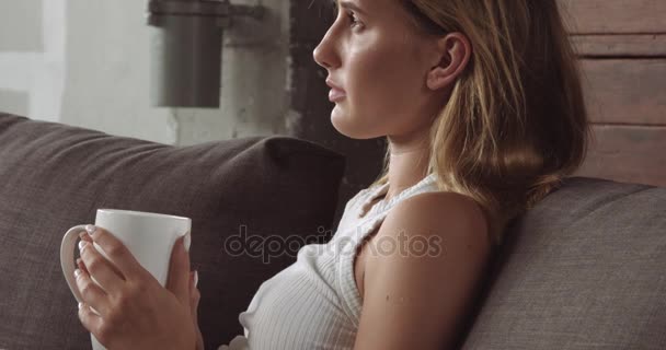 Mujer rubia joven relajándose en el sofá — Vídeos de Stock