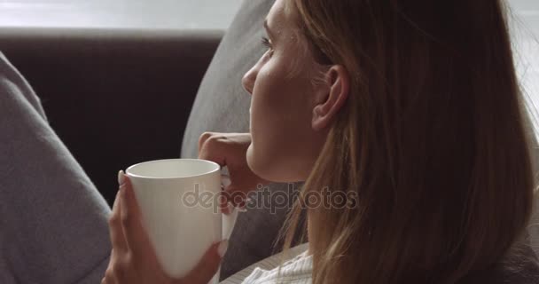Ung blond kvinna avkopplande på soffan — Stockvideo