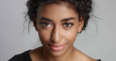 mükemmel hafif kahverengi deri ve kameraya gülümseyen güzel kıvırcık siyah saçlı genç kız