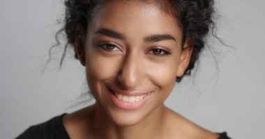 mükemmel hafif kahverengi deri ve kameraya gülümseyen güzel kıvırcık siyah saçlı genç kız