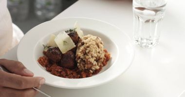 Bir yatakta üstüne parmesan dilimleri ile havuç pirinç ve mantar, İsveç köftesi yemek yeme eller mans