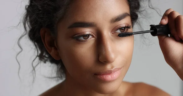 Adorable teenage Middle Eastern girl with great skin applying mascara to her long lashes — Stock Photo, Image