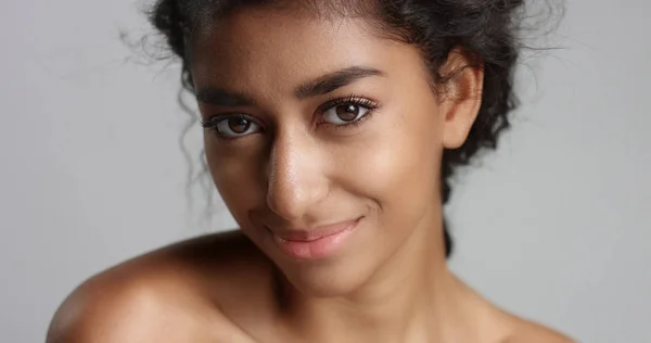 Happy serene young woman with beautiful olive skin and curly hair ideal skin and brown eyes in studio — Stock Photo, Image