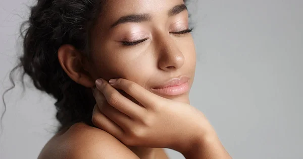 Glücklich abgeklärte junge Frau mit schöner Olivenhaut und lockigem Haar ideale Haut und braune Augen im Studio — Stockfoto