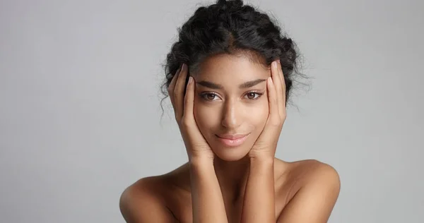 Happy serene young woman with beautiful olive skin and curly hair ideal skin and brown eyes in studio — Stock Photo, Image