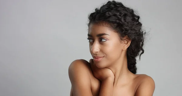 Happy serene young woman with beautiful olive skin and curly hair ideal skin and brown eyes in studio — Stock Photo, Image