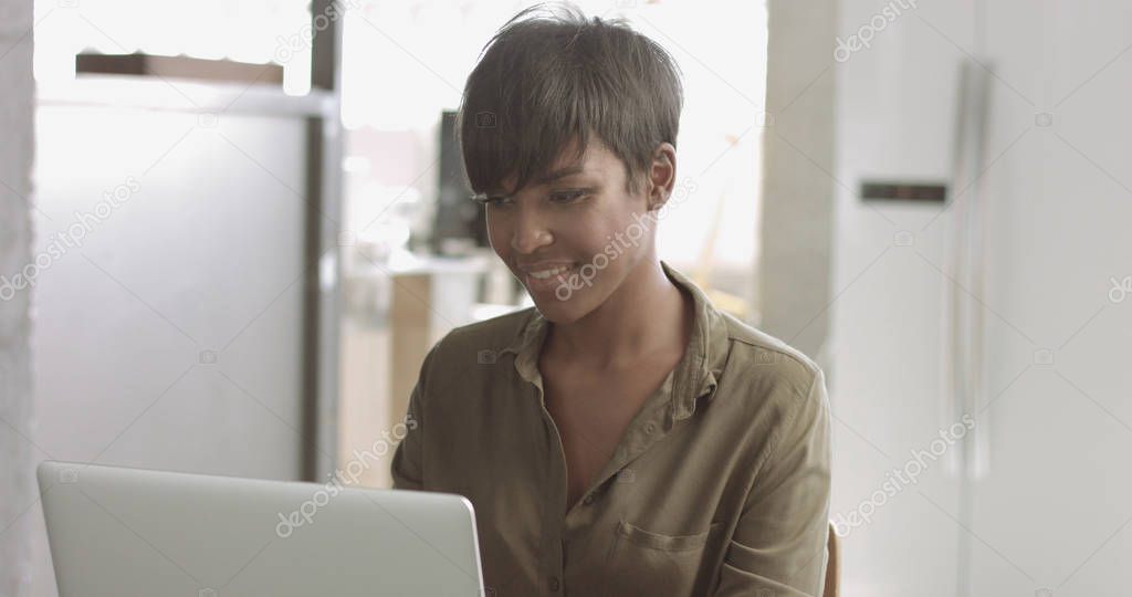 Cute young black woman in loft style office