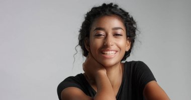 mükemmel hafif kahverengi deri ve kameraya gülümseyen güzel kıvırcık siyah saçlı genç kız