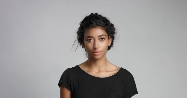 Ung flicka med perfekt ljus brun hud och vackert lockigt svart hår ler mot kameran — Stockfoto