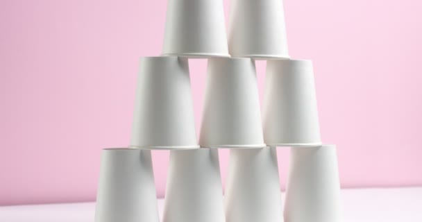Tower made of white paper cups on pink background — Stock Video ...