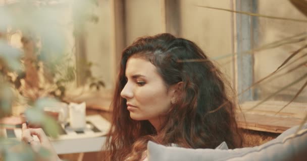 Woman With Long Curly Hair Relaxing And Smoking Stock Video
