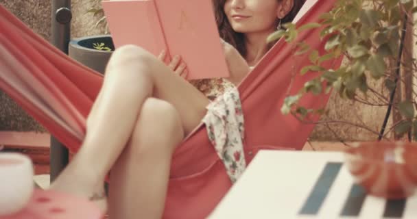 Mooie langharige meisje ontspannen in een hangmat — Stockvideo