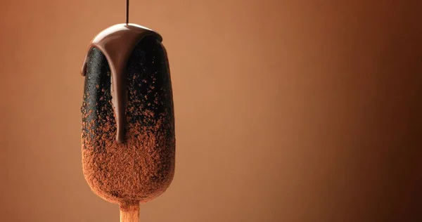 Schokoladeneis auf einem Stock und flüssige Schokolade darüber. verschiedene Schokoladentexturen — Stockfoto