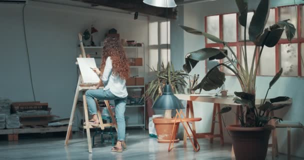 Bonito tintas menina de cabelos vermelhos em seu estúdio — Vídeo de Stock