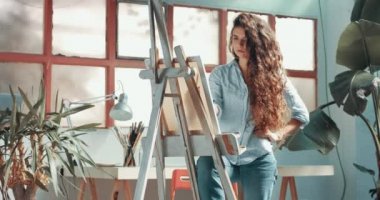 Sevimli kırmızı saçlı kız boyalar onun Studio