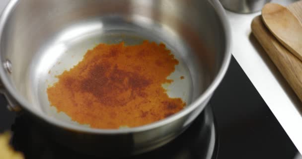 Adding paprika to hot oil in pan — Stock Video
