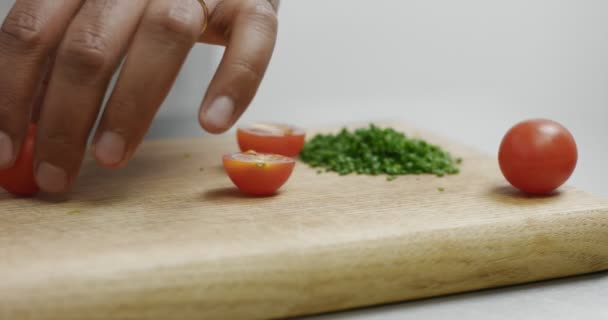 Corte de tomates cereja ao lado de uma pilha de cebolinha picada — Vídeo de Stock