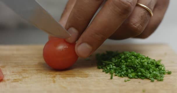 Cięcie pomidorów cherry obok kupie posiekanego szczypiorku — Wideo stockowe