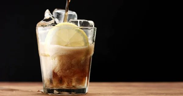 Cocktail met cola en limoenen plakjes geïsoleerd op zwart — Stockfoto