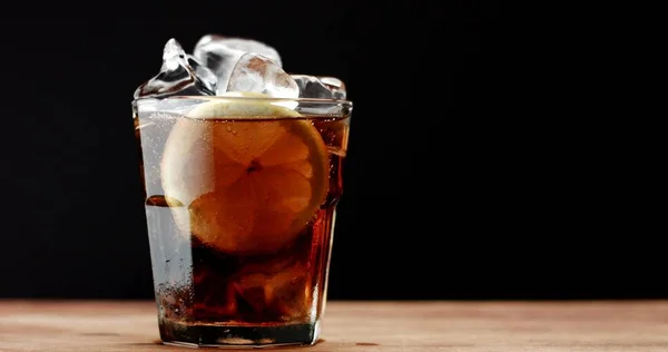 Cocktail mit Cola und Limettenscheiben isoliert auf schwarz — Stockfoto