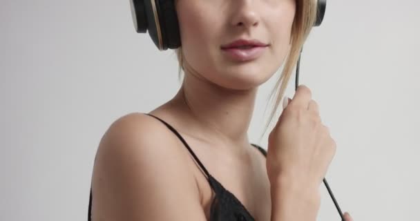 Menina loira em fones de ouvido suspensos — Vídeo de Stock