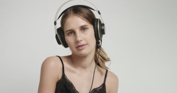 Мила дівчина в нижній білизні танцює до музики в навушниках — стокове відео