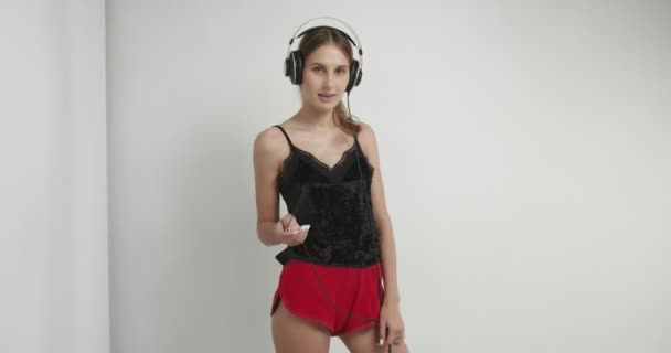 Гаряча дівчина в нижній білизні і навушники — стокове відео