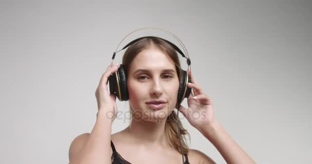 Portret van een jonge vrouw in hoofdtelefoon — Stockvideo